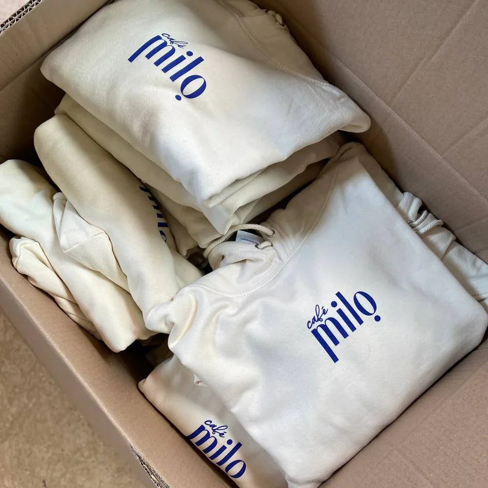 Sweats unisexe blancs 'café milo' pliés dans une boîte, streetwear fait main à Antibes